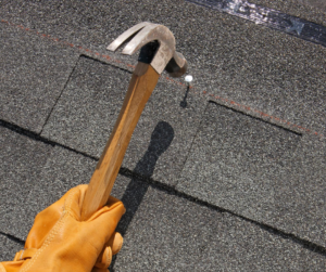 person hammering nail into roof